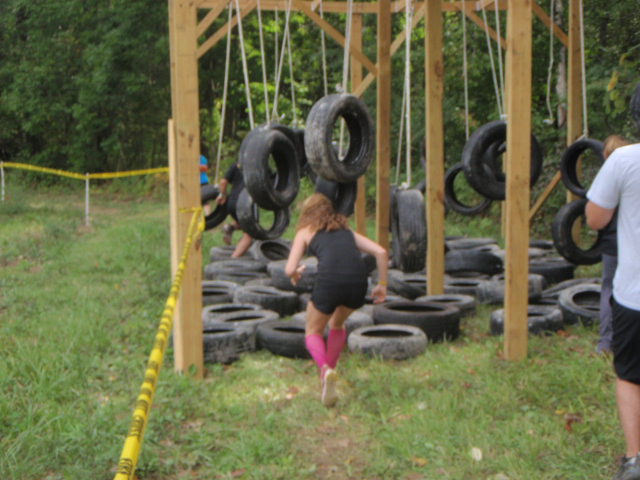 Heather Hart ducking to run through an  obstacle full of swinging tires during the 2012 Hero Rush Obstacle Course Race
