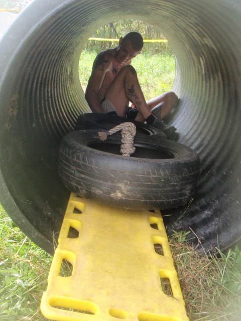 man drags tires on a board through a tunnel during the 2012 Hero Rush Obstacle Course Race