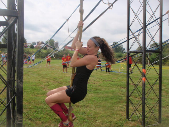 Heather Hart climbs up a knotted fire hose being used as a rope climb during an obstacle at the 2012 Hero Rush Obstacle Course Race
