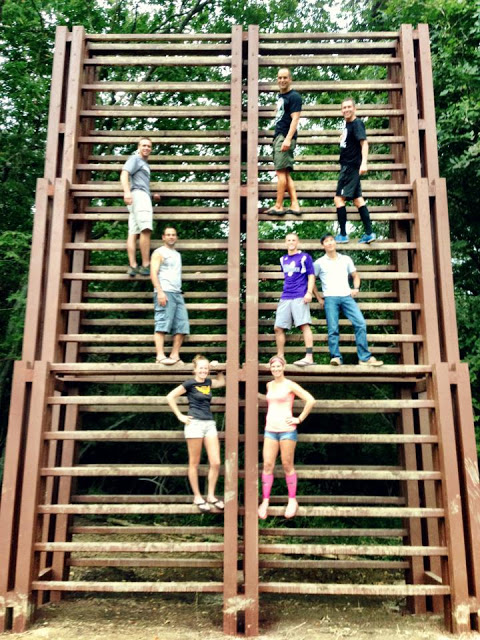 Image of OCR athletes standing on a large ladder obstacle known as "The Castle" at the Mud Guts and Glory OCR course