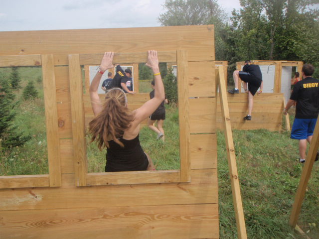 View of woman jumping through wooden windows obstacle during the 2012 Hero Rush Obstacle Course Race