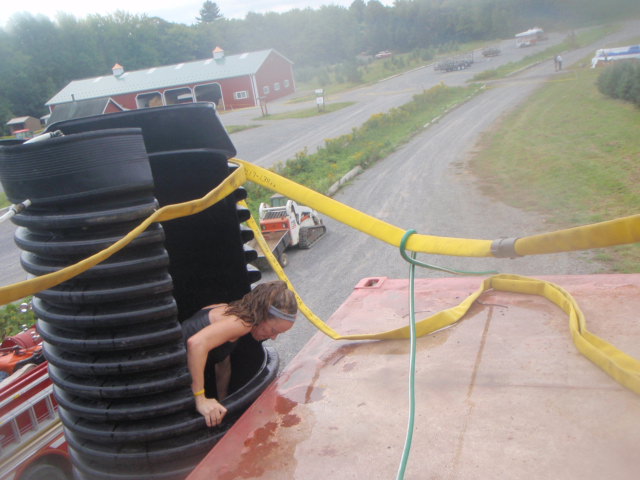 Heather Hart crawling up and out of a tube onto a platform during the 2012 Hero Rush Obstacle Course Race