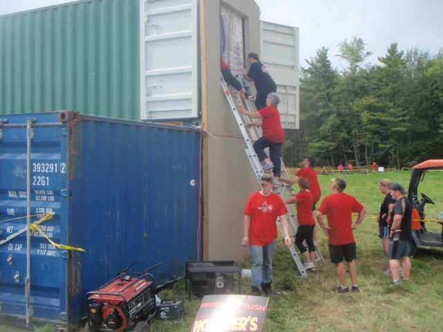 2012 Hero Rush Obstacle Course Race participants climb up a ladder and into storage containers