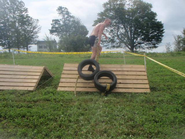 Geoff Hart drags tires attached to a fire hose over a wooden obstacle during the 2012 Hero Rush Obstacle Course Race