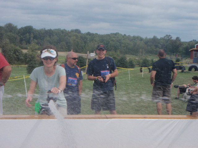 Image of woman shooting water from a fire hose at participants during the 2012 Hero Rush Obstacle Course Race