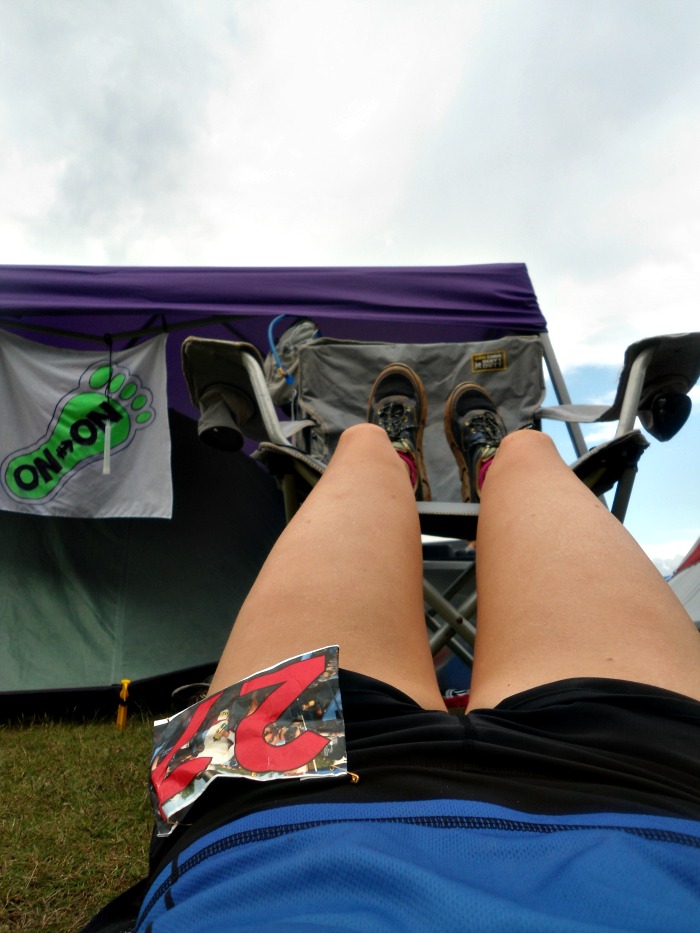 Legs resting in chair with runner laying on the ground in the middle of a race