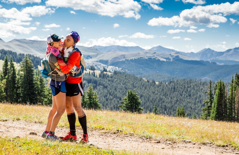 Heather Hart and Geoffrey hart, ultramarathon coaches, stop for a kiss in front of the mountains during the TransRockies Run Stage Race