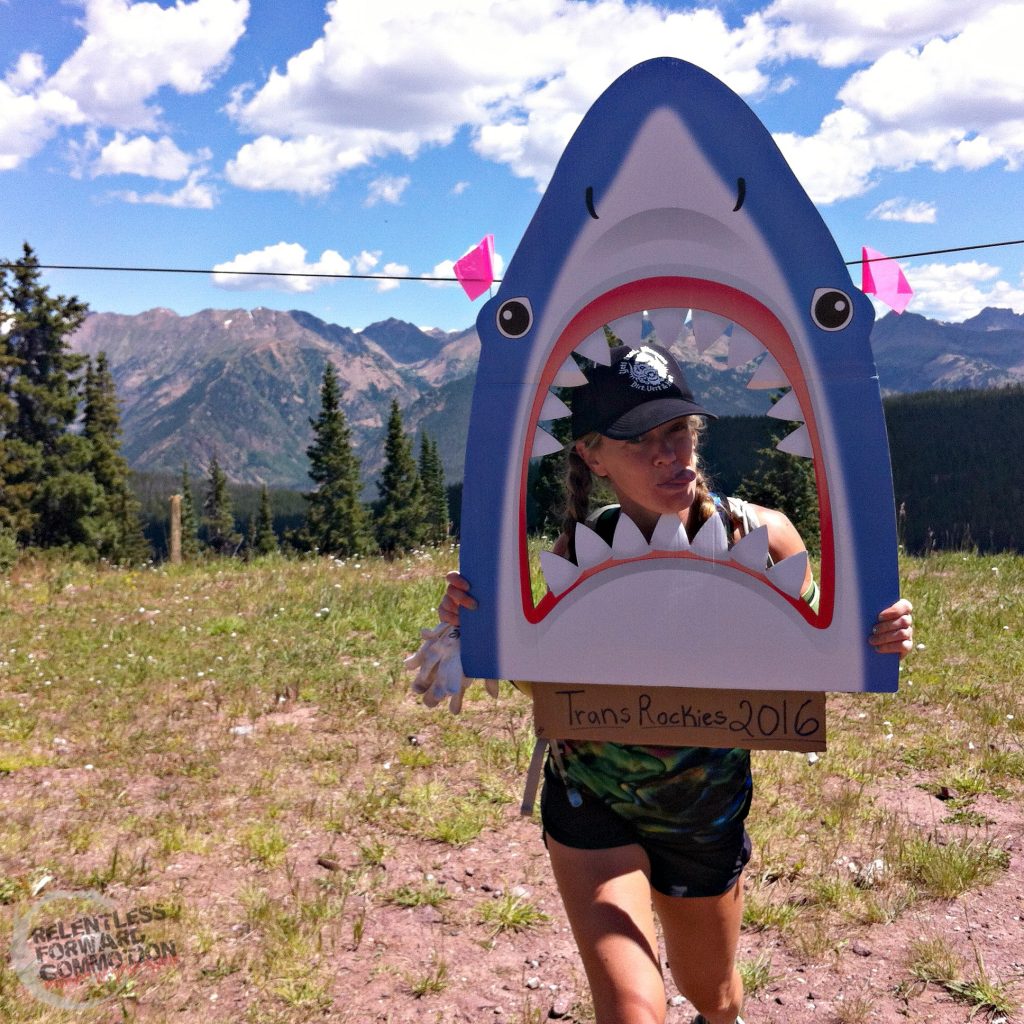 Heather Hart ultramarathon coach smiling in a cardboard shark cutout face at the Transrockies run stage race