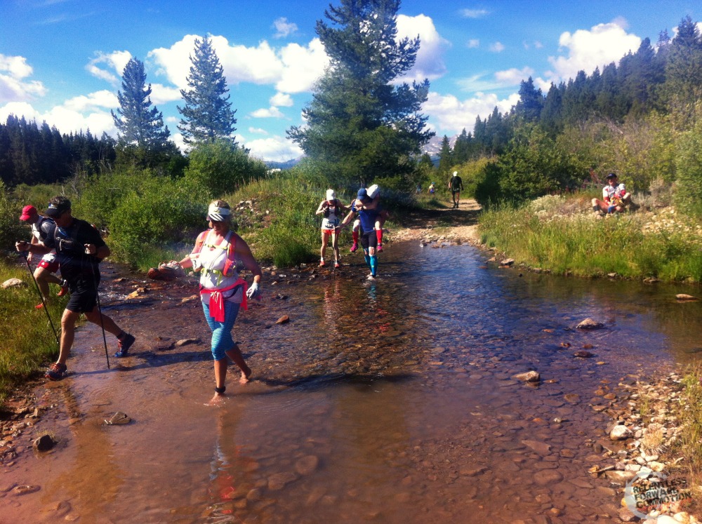 Image of runners tiptoeing across a stream during the 2016 TransRockies Run 6 Day Stage Race Ultramarathon 