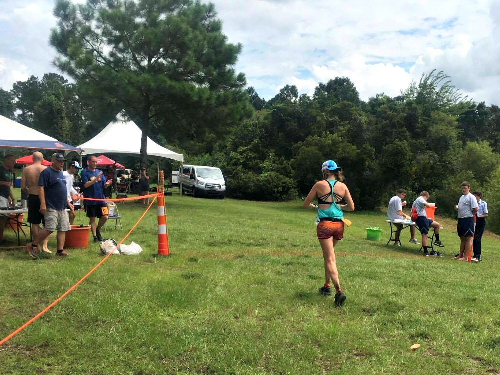 Heather Hart running into a finish line on the grass during an ultramarathon