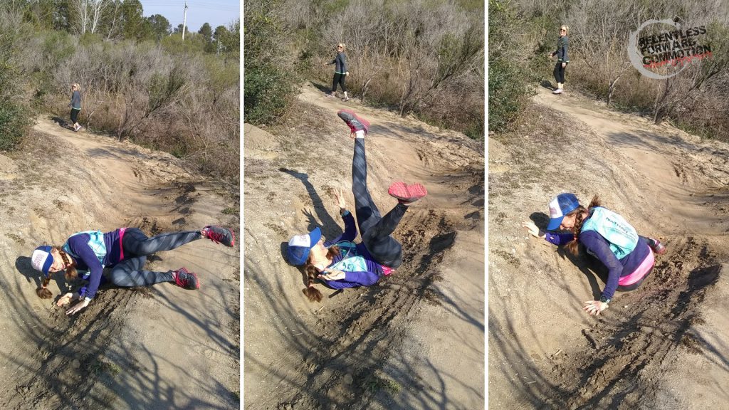 a trail runner trips and falls while running on a dirt trail