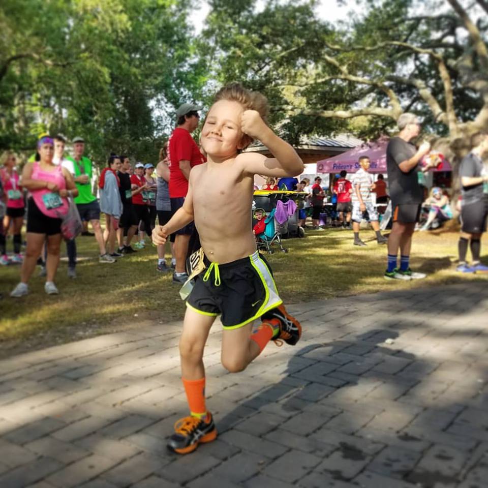 happy kid smiling and cheering during a fun run race