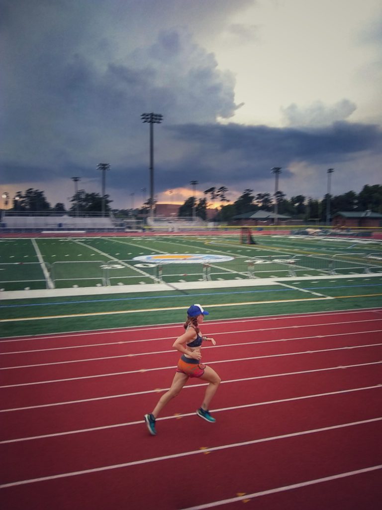 photo of Heather Hart running on a track while performing a speed interval running workout