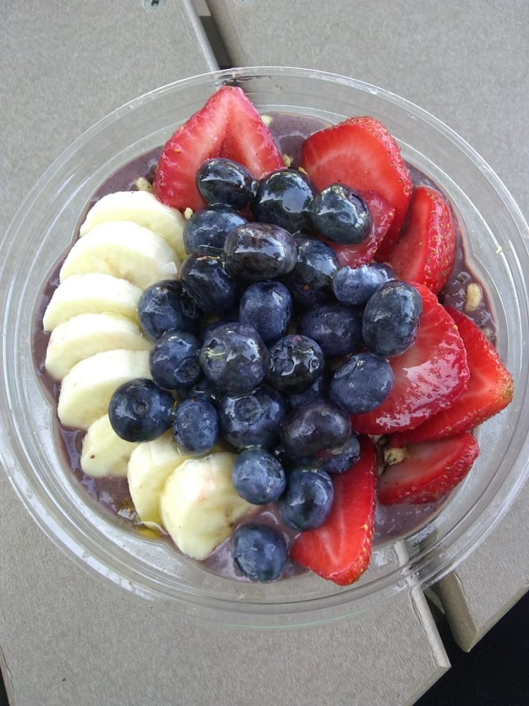 Bowl of yogurt with bananas, blueberries, and strawberries on top