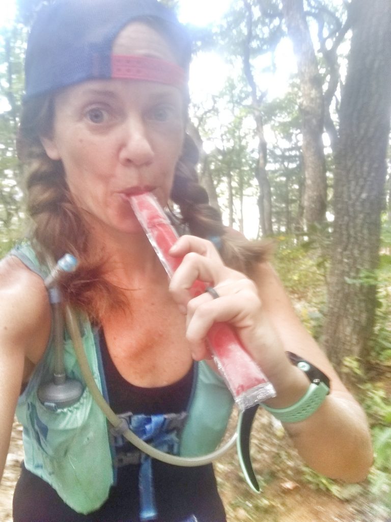 runner eating a Popsicle mid ultramarathon