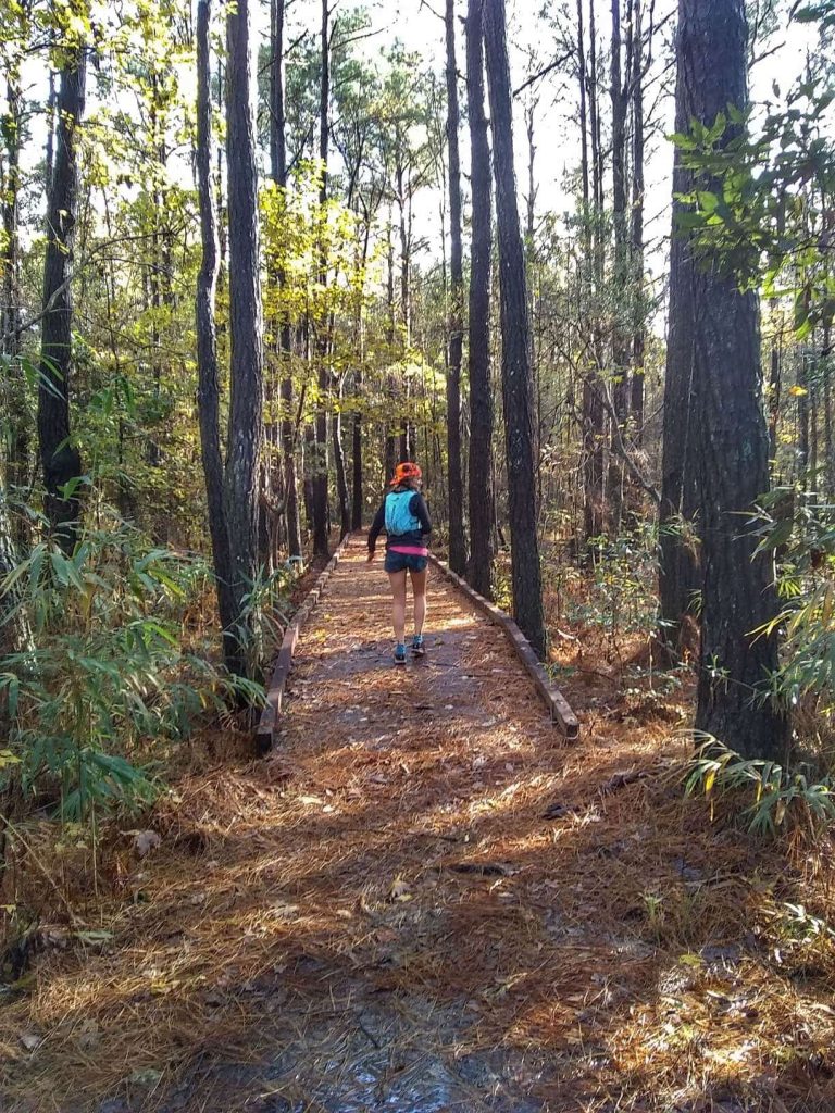 Ultrarunner walking across a bridge in the forest at the Francis Marion National Forest
