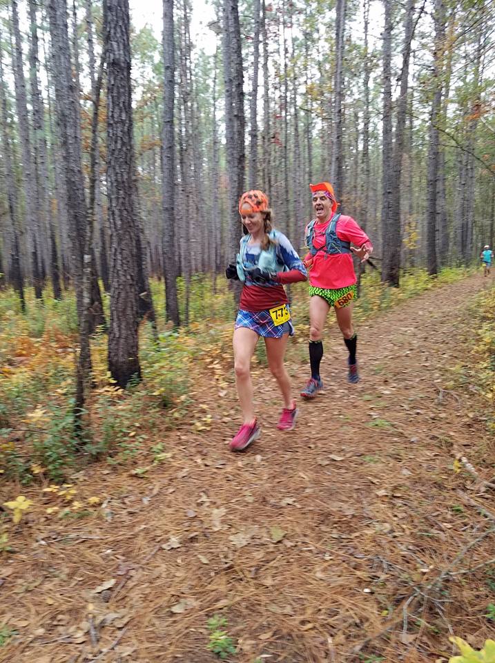 Wearing bright colors while running down a trail in the fall