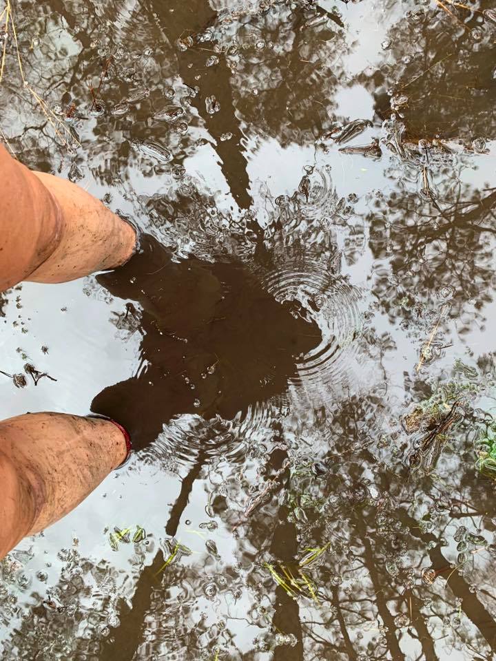 A runner standing in ankle deep mud