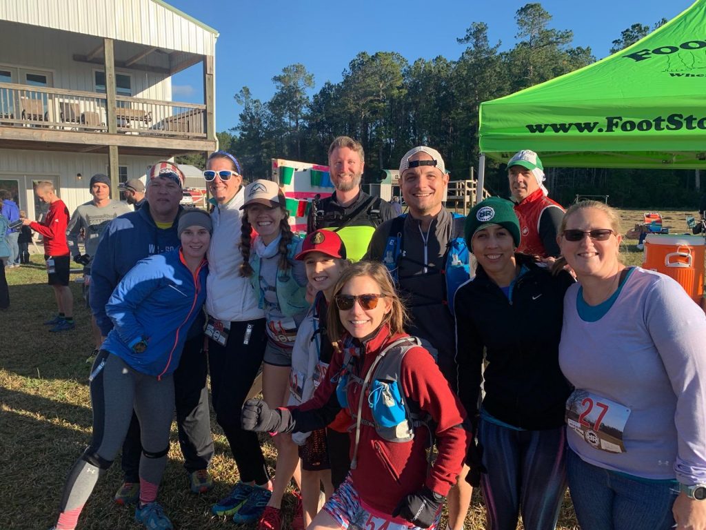 A group of runners posing together before the start of an ultramarathon 