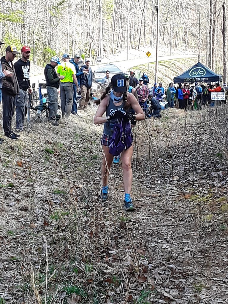 Trail runner at the Georgia Death Race refilling her hydration pack at an aid station