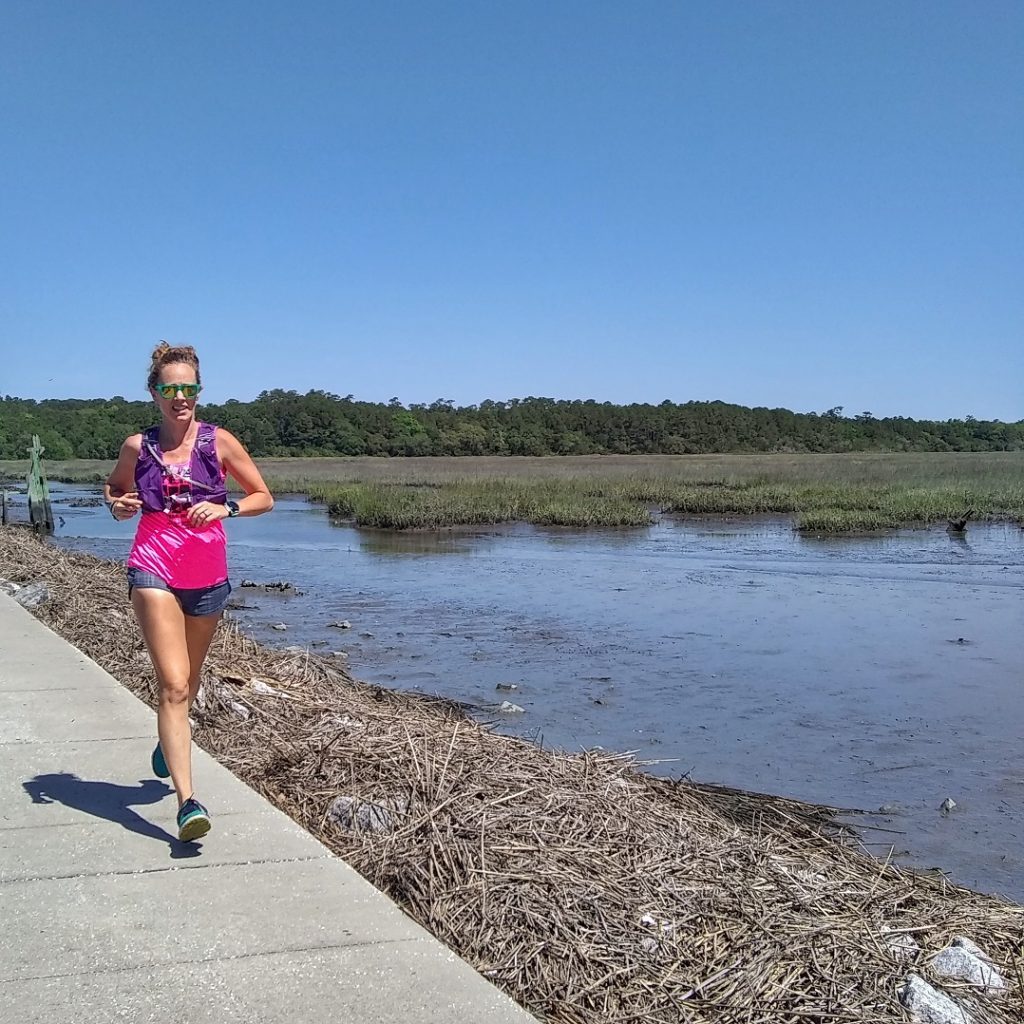 Heather Hart running down a causeway at Huntington Beach State Park