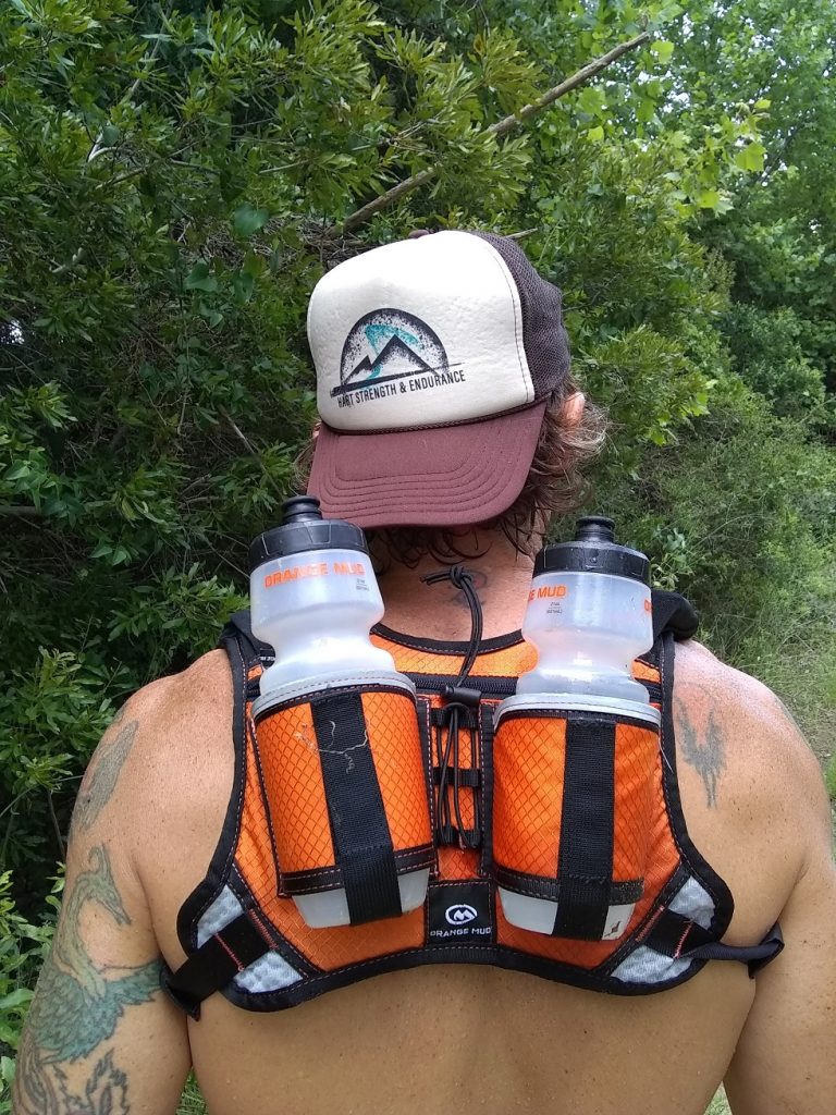 Image of an Orange Mud Double Quiver hydration pack on ultrarunner Geoffrey Hart 