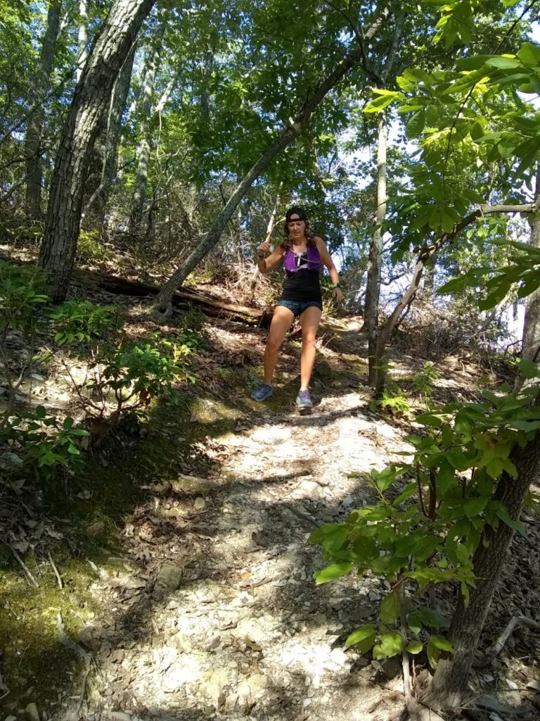 Trail runner running down a mountain trail at Morrow Mountain State Park