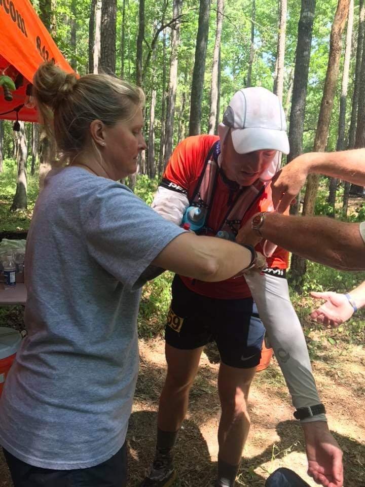 Preparing your crew for an ultramarathon.  Crew member puts ice in runner's arm sleeves. 