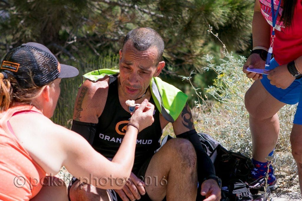 Crew member helps feed runner during an ultramarathon 