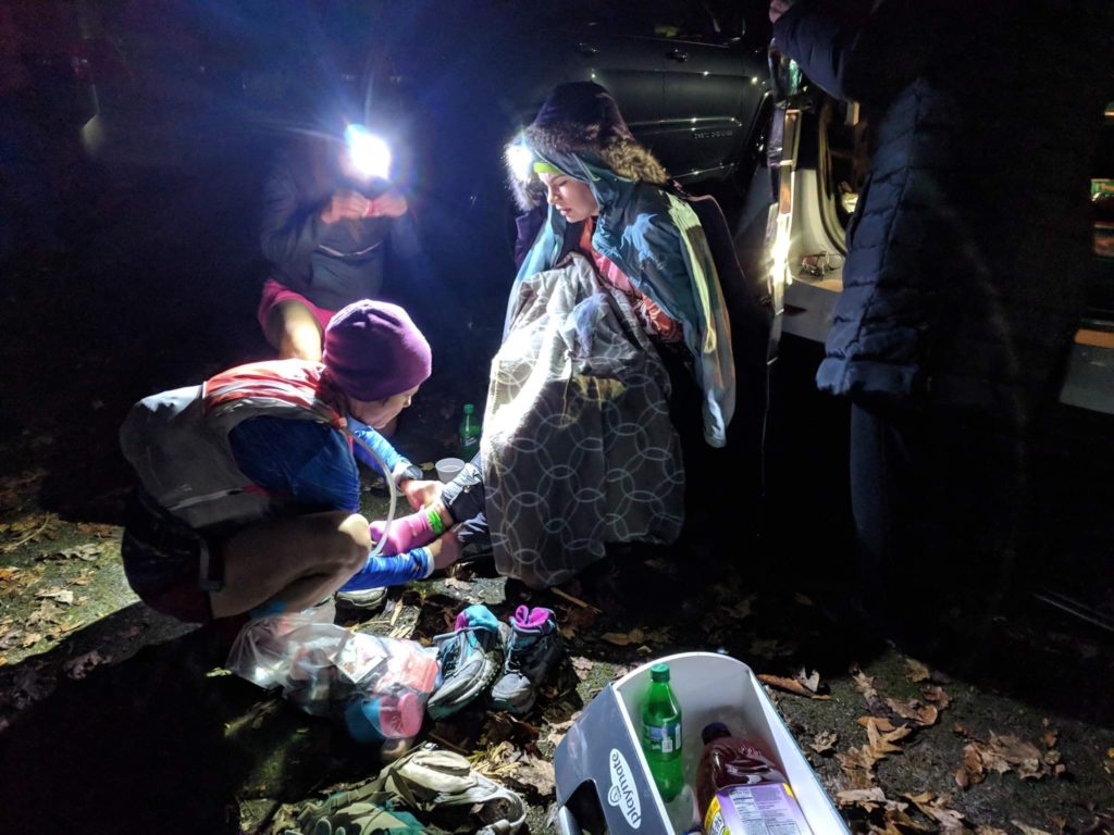 Ultramarathon crew/pacer helps runner with their socks and shoes