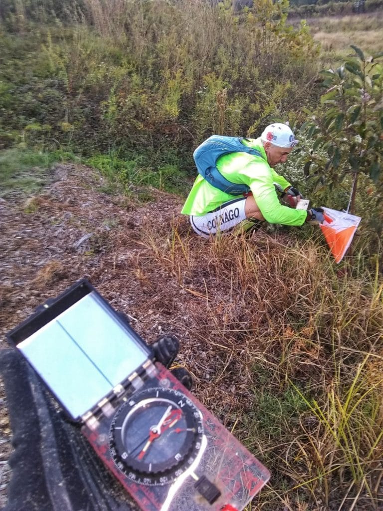 Adventure Racing participant finding a check point in the woods using a map and compass