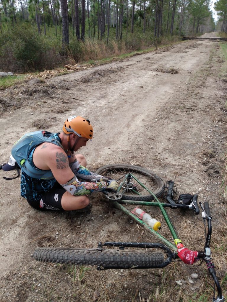 Adventure racer fixing bike during an adventure race