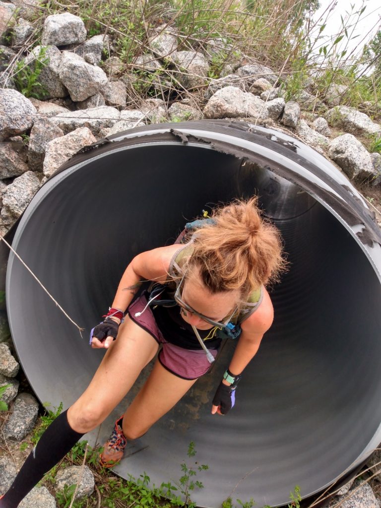 Heather crawling through a drainage tube during The Lockdown Virtual Adventure Race