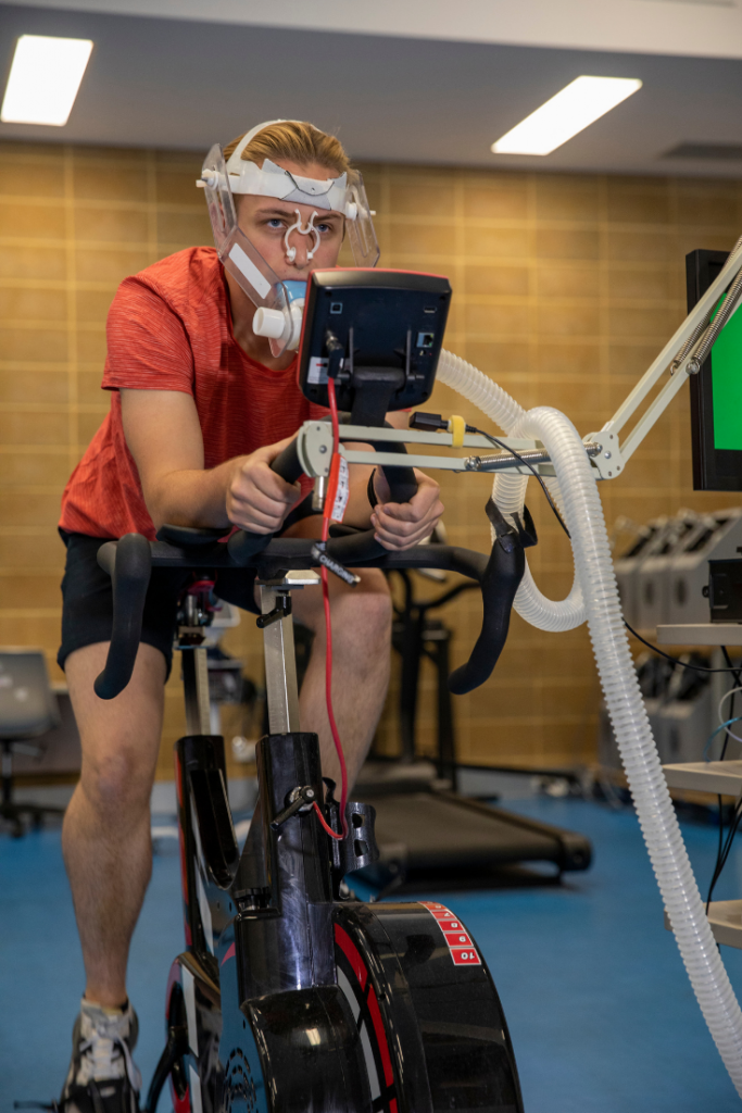 Athlete performing a VO2max test on a bicycle in an exercise science lab