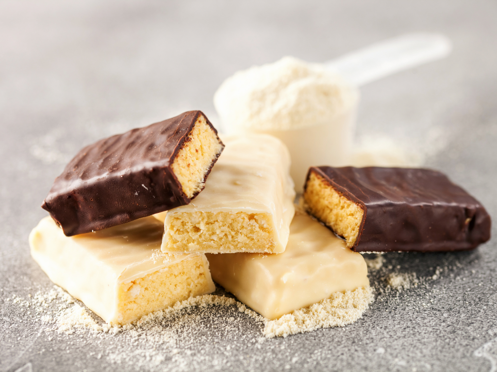 A photo of protein bars and protein powder.  Focusing only on protein and not replenishing with glycogen is one of the top nutrition mistakes runners make. 