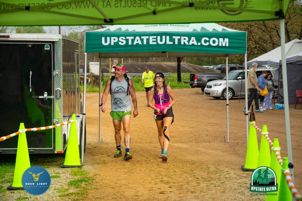 Ultrarunners smiling through mental lows during the later stages of a 100 mile ultramarathon 