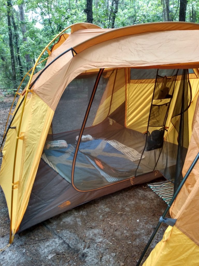 View inside of a tent with sleeping bags laid out on the floor. 