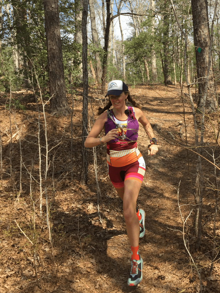 Heather Hart wearing Coeur Sports Triathlon shorts trail running through the forest