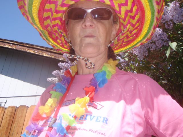 photo of a female hash house harrier wearing bright and colorful attire before a hash running trail