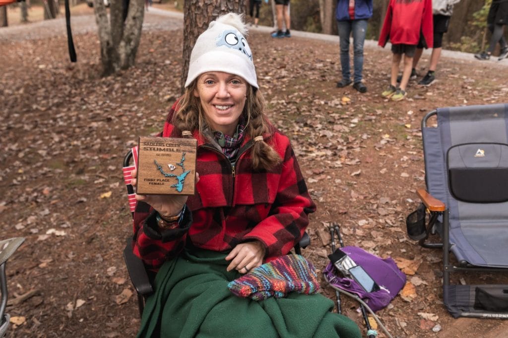 Heather Hart sitting in a chair wrapped in blankets and warm clothes after finishing the Sadlers Creek Stumble 24 hour Ultramarathon