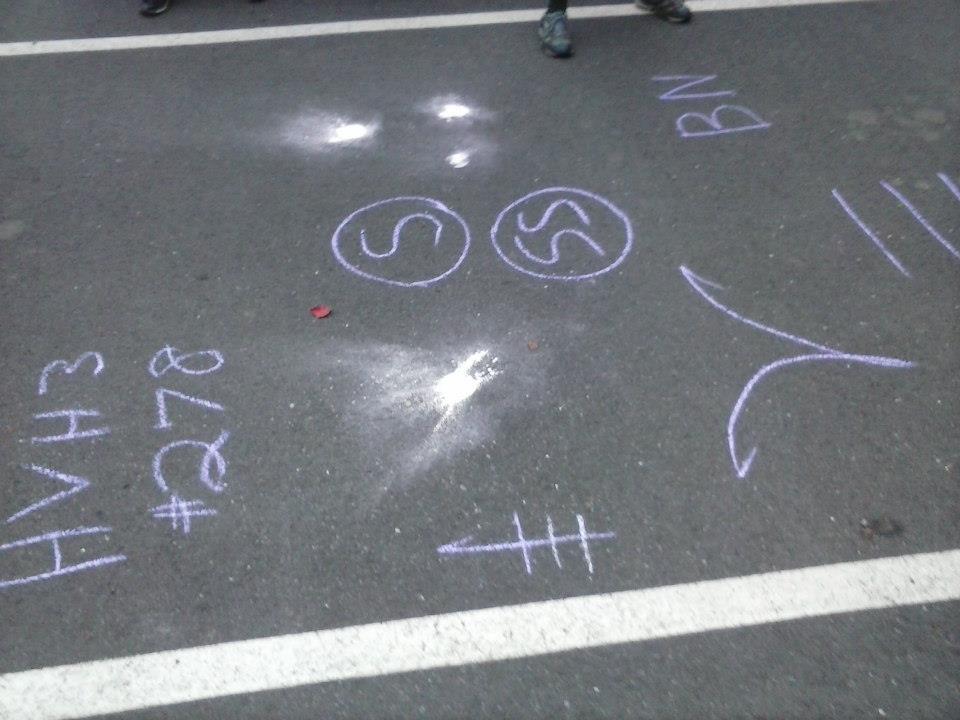 Image of chalk marks, flour marks, and other symbols on pavement,  laid by the hash house harriers on a hashing trail