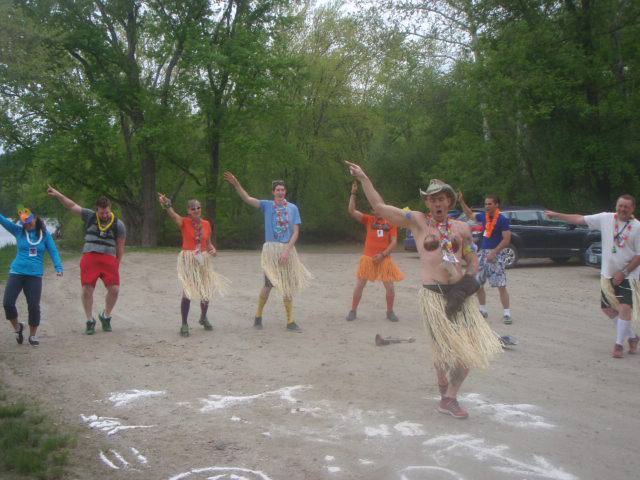 Group of hash house harriers warming up with a song and dance during an opening circle of a hashing trail