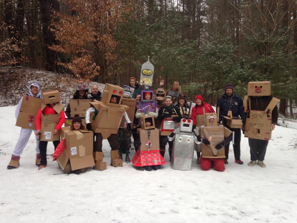 Image of a group of Hash House Harriers posing for a group picture in the snow, all wearing robot costumes made out of cardboard