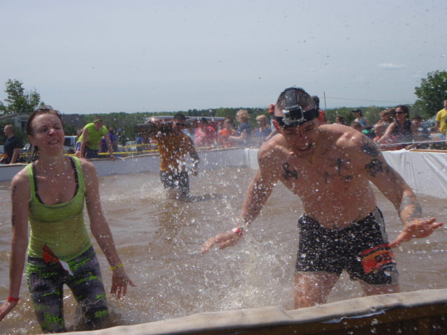 Two obstacle course racers splash in a pool at the the Hero Rush OCR
