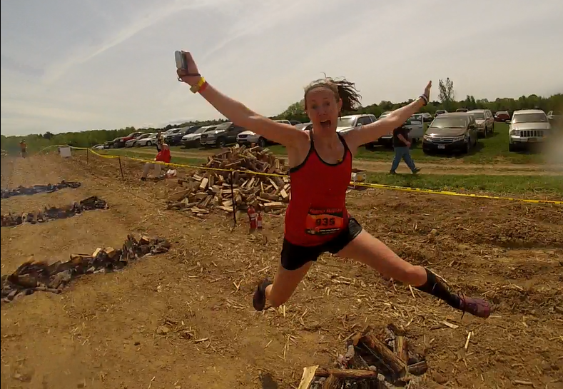 Heather Hart leaps over a fire during the Hero Rush OCR