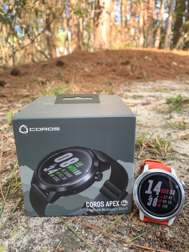 Photo of the COROS APEX 46mm next to it's box, outdoors in the grass