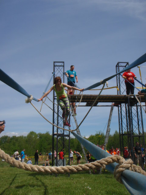 Woman carefully balances through a ropes obstacle at the the Hero Rush OCR