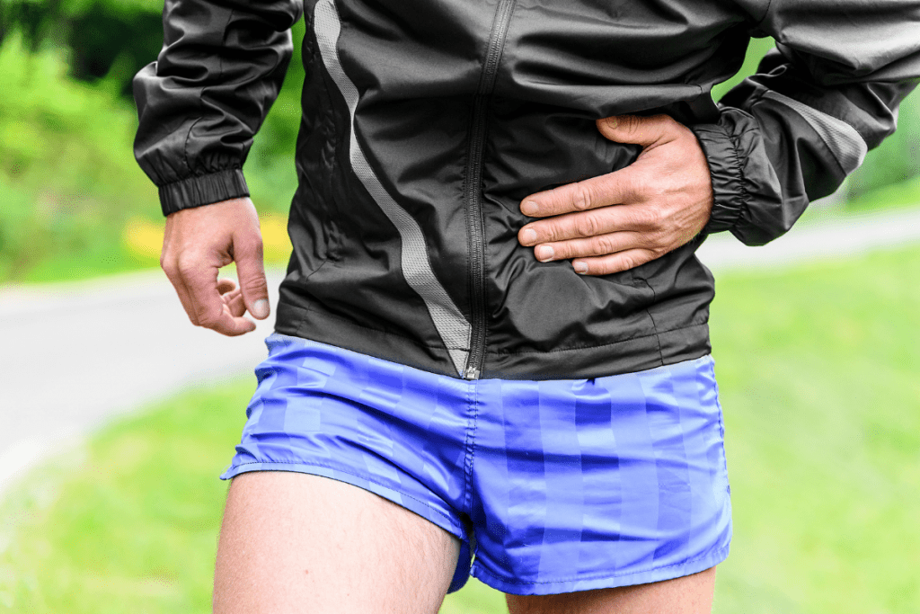 Runner holds his abdomen in pain after succumbing to a runner's side stitch 