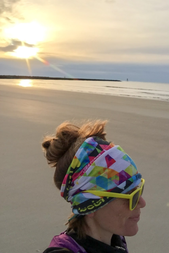 Heather Hart running on a beach in the sunrise