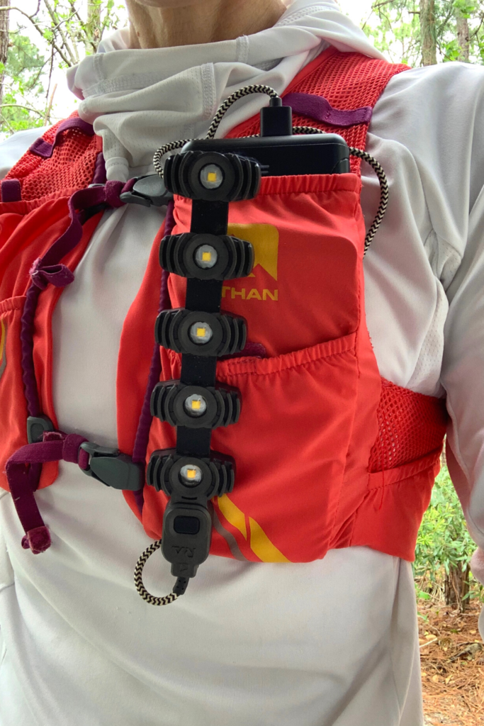Image of the Kogalla RA Adventure Light attached to the running hydration vest of an ultrarunner